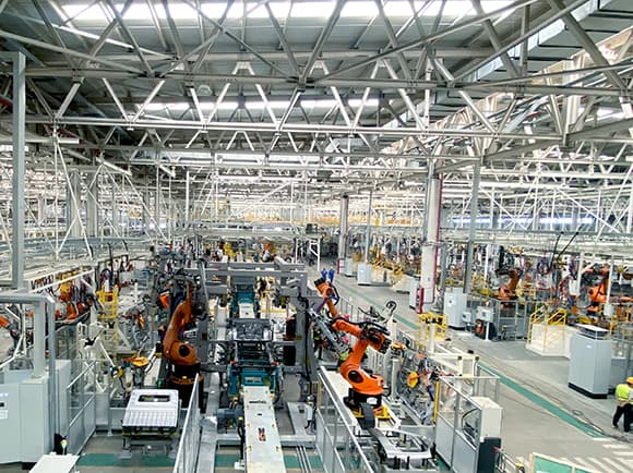 Vehicle production line factory floor with robotic workstations